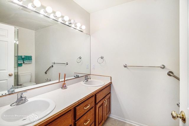 6063 Steeplechase Dr, Grand Blanc, MI 48439 - bathroom with double vanity, toilet, and tile patterned flooring