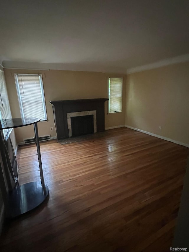 20258 Fairport St, Detroit, MI 48205 - unfurnished living room with wood finished floors, baseboards, a baseboard heating unit, and a fireplace