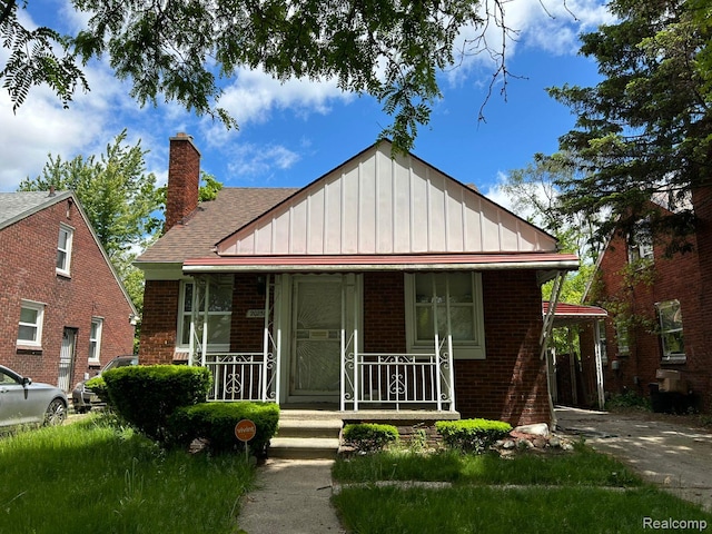 20258 Fairport St, Detroit, MI 48205 - bungalow-style house with covered porch, brick siding, board and batten siding, a chimney, and a shingled roof