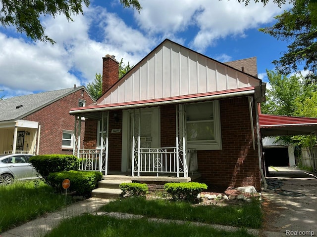 20258 Fairport St, Detroit, MI 48205 - bungalow-style house with brick siding, a porch, board and batten siding, and a chimney