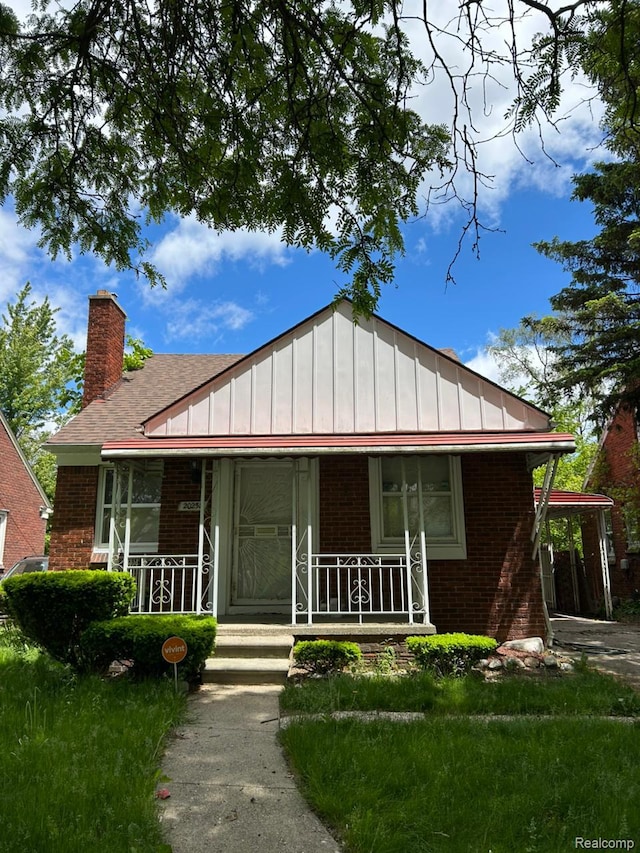 20258 Fairport St, Detroit, MI 48205 - view of front of property with brick siding, a porch, a chimney, and board and batten siding