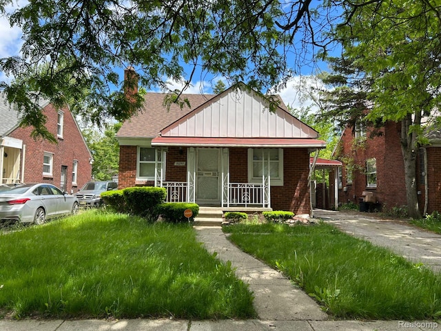 20258 Fairport St, Detroit, MI 48205 - bungalow with board and batten siding, a porch, brick siding, and a shingled roof