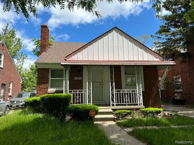 20258 Fairport St, Detroit, MI 48205 - bungalow-style house featuring covered porch, brick siding, board and batten siding, a chimney, and roof with shingles