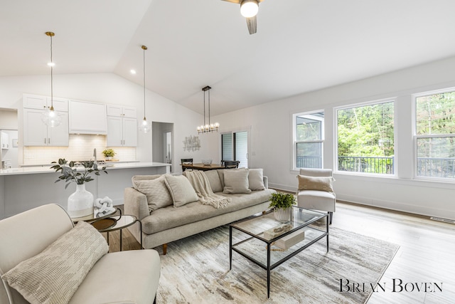 4846 Honeycrisp Dr NE, Rockford, MI 49341 - living room featuring light wood-type flooring, a chandelier, high vaulted ceiling, and ceiling fan