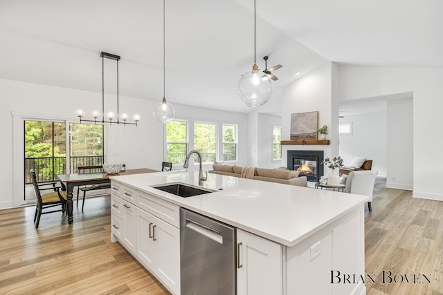 4846 Honeycrisp Dr NE, Rockford, MI 49341 - kitchen featuring dishwasher, a sink, a glass covered fireplace, light wood finished floors, and white cabinets