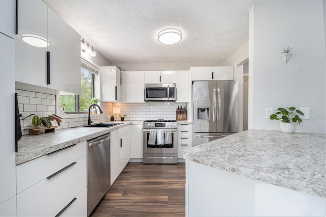 3360 Brook Trl SE, Grand Rapids, MI 49508 - kitchen with stainless steel appliances, a sink, white cabinets, light countertops, and a textured ceiling
