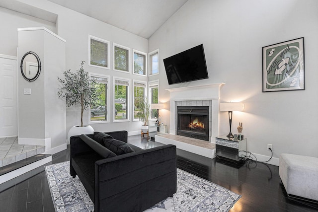 3360 Brook Trl SE, Grand Rapids, MI 49508 - living room featuring high vaulted ceiling, a tiled fireplace, wood finished floors, and baseboards