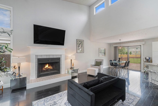 3360 Brook Trl SE, Grand Rapids, MI 49508 - living room with a towering ceiling, wood finished floors, a tiled fireplace, and baseboards