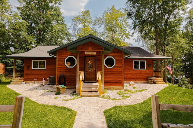 376 Highview Rd, Traverse City, MI 49696 - chalet / cabin featuring a front yard, central air condition unit, and roof with shingles