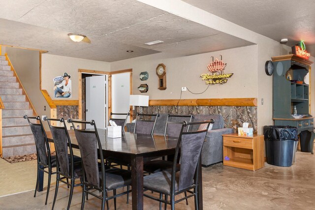 376 Highview Rd, Traverse City, MI 49696 - dining space featuring finished concrete flooring, stairway, and a textured ceiling