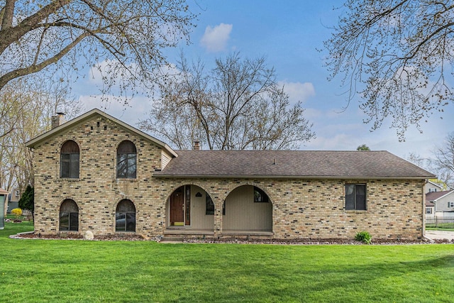 608 N Wickshire Ln, Durand, MI 48429 - view of front facade featuring a chimney, brick siding, a front lawn, and roof with shingles
