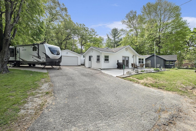 13774 Chrysler St NE, Gowen, MI 49326 - view of front of home featuring a detached garage, an outbuilding, a front lawn, and view of wooded area
