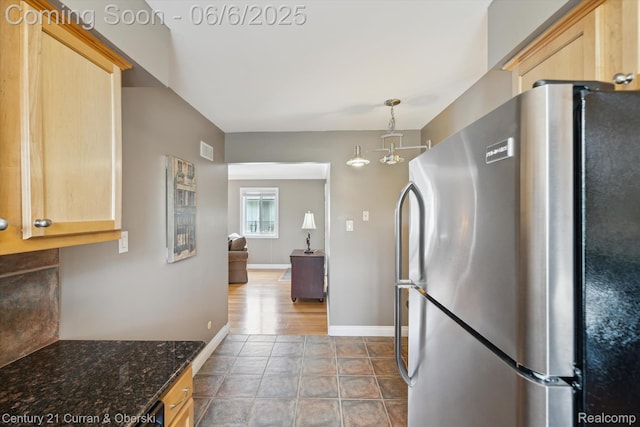 307 N Eton St, Birmingham, MI 48009 - kitchen with freestanding refrigerator, light brown cabinetry, dark stone countertops, baseboards, and dark tile patterned flooring