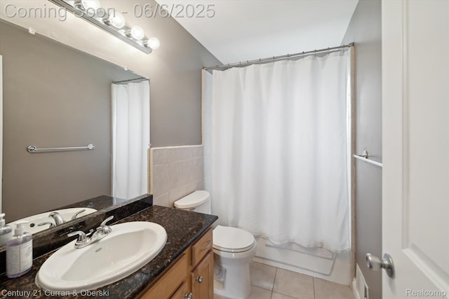 307 N Eton St, Birmingham, MI 48009 - full bathroom with tile patterned flooring, vanity, toilet, tile walls, and shower / tub combo