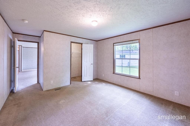 229 Spear St SW, Grand Rapids, MI 49548 - unfurnished bedroom featuring carpet floors, crown molding, a textured ceiling, and a closet