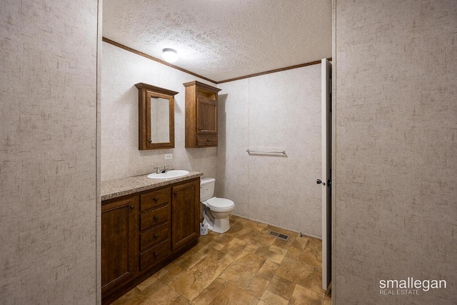 229 Spear St SW, Grand Rapids, MI 49548 - bathroom with vanity, crown molding, stone finish floors, toilet, and a textured ceiling