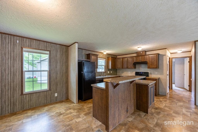 229 Spear St SW, Grand Rapids, MI 49548 - kitchen with freestanding refrigerator, stove, a center island, wooden walls, and a breakfast bar area