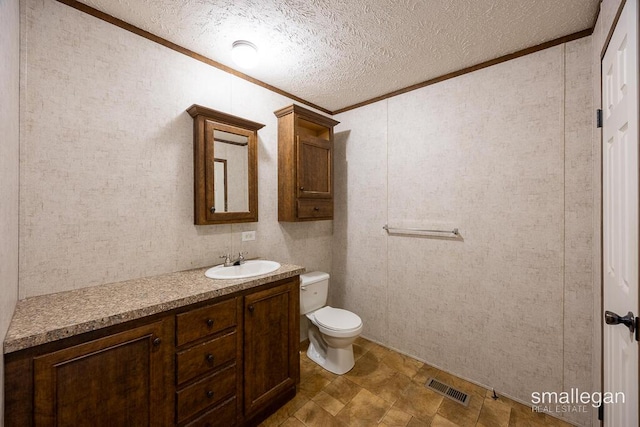 229 Spear St SW, Grand Rapids, MI 49548 - bathroom featuring crown molding, vanity, toilet, a textured ceiling, and stone finish floors