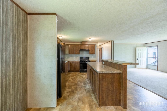 229 Spear St SW, Grand Rapids, MI 49548 - kitchen with black appliances, a center island, brown cabinets, a textured ceiling, and under cabinet range hood
