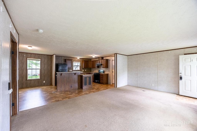 229 Spear St SW, Grand Rapids, MI 49548 - kitchen featuring open floor plan, range, light colored carpet, a textured ceiling, and freestanding refrigerator