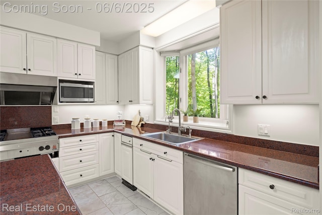 6212 Bromley Ct, West Bloomfield, MI 48322 - kitchen with appliances with stainless steel finishes, a sink, dark countertops, light marble finish floors, and white cabinets