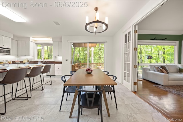6212 Bromley Ct, West Bloomfield, MI 48322 - dining room with light marble finish floors, healthy amount of natural light, and a chandelier