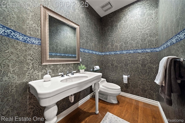 6212 Bromley Ct, West Bloomfield, MI 48322 - bathroom with wood finished floors, toilet, a sink, and wallpapered walls