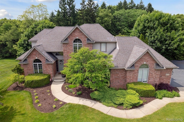 3468 High Hillcrest Dr, Howell, MI 48843 - traditional-style home featuring brick siding, roof with shingles, and a front yard