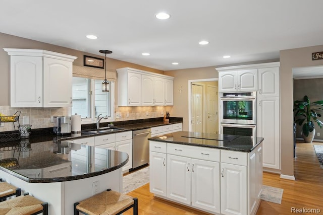 3468 High Hillcrest Dr, Howell, MI 48843 - kitchen featuring stainless steel appliances, white cabinets, backsplash, light wood-style flooring, and recessed lighting