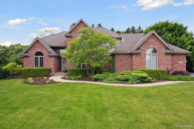 3468 High Hillcrest Dr, Howell, MI 48843 - view of front facade featuring brick siding, a front lawn, and roof with shingles