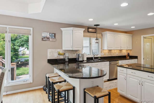 3468 High Hillcrest Dr, Howell, MI 48843 - kitchen featuring stainless steel dishwasher, a sink, a kitchen breakfast bar, white cabinets, and light wood-style flooring