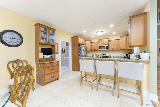 1235 Joann Ln, Williamston, MI 48895 - kitchen with stainless steel appliances, a peninsula, recessed lighting, glass insert cabinets, and baseboards