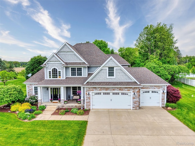 1235 Joann Ln, Williamston, MI 48895 - view of front facade with covered porch, concrete driveway, a shingled roof, stone siding, and a garage