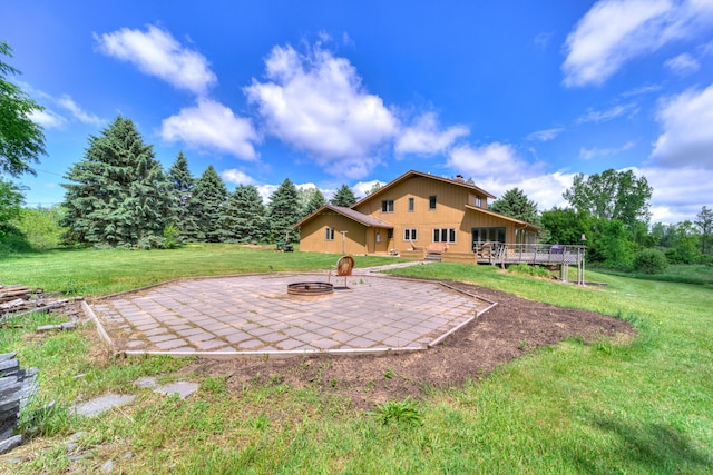 4470 Peach Ridge Ave NW, Grand Rapids, MI 49544 - back of house featuring a wooden deck, an outdoor fire pit, a patio, and a yard