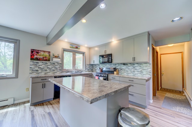 4470 Peach Ridge Ave NW, Grand Rapids, MI 49544 - kitchen featuring appliances with stainless steel finishes, tasteful backsplash, light wood finished floors, light countertops, and a center island