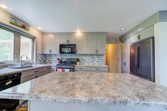 4470 Peach Ridge Ave NW, Grand Rapids, MI 49544 - kitchen featuring black appliances, a sink, light countertops, backsplash, and gray cabinets