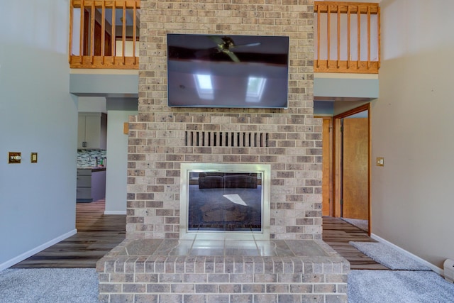 4470 Peach Ridge Ave NW, Grand Rapids, MI 49544 - unfurnished living room featuring baseboards, ceiling fan, a fireplace, and wood finished floors