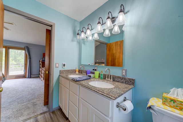 4470 Peach Ridge Ave NW, Grand Rapids, MI 49544 - bathroom with toilet, double vanity, wood finished floors, and baseboard heating