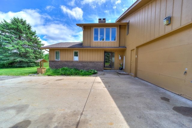 4470 Peach Ridge Ave NW, Grand Rapids, MI 49544 - view of front facade featuring a chimney, brick siding, and board and batten siding