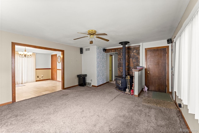 19200 Roger St, Melvindale, MI 48122 - unfurnished living room with a wood stove, a ceiling fan, a chandelier, carpet flooring, and baseboards