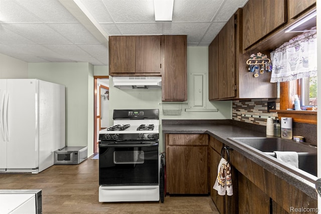 19200 Roger St, Melvindale, MI 48122 - kitchen with under cabinet range hood, white appliances, a drop ceiling, dark countertops, and wood finished floors