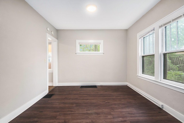 415 Cutler St SW, Grand Rapids, MI 49507 - empty room with healthy amount of natural light, dark wood-type flooring, and baseboards