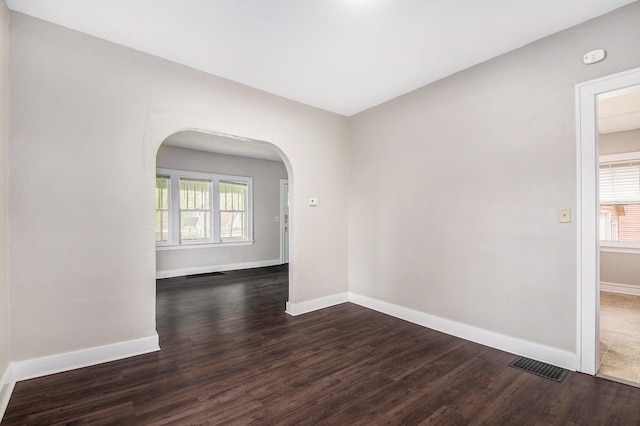 415 Cutler St SW, Grand Rapids, MI 49507 - empty room with arched walkways, dark wood-style flooring, and baseboards