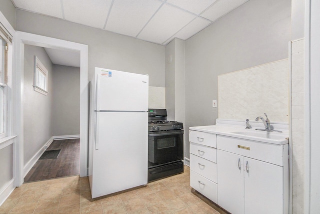 415 Cutler St SW, Grand Rapids, MI 49507 - kitchen featuring black range with gas cooktop, freestanding refrigerator, a sink, light countertops, and white cabinetry
