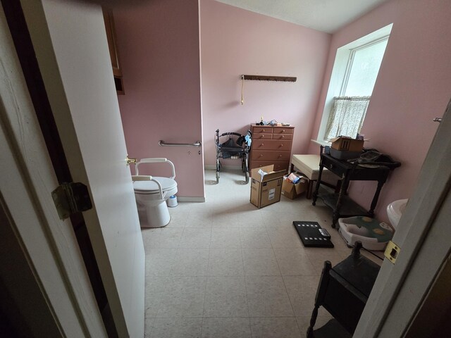 487 E Elizabeth St, Stockbridge, MI 49285 - bathroom with tile patterned floors, toilet, and baseboards