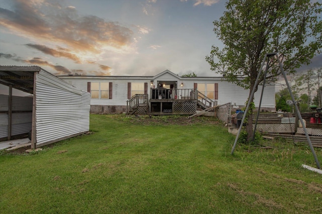 15250 142nd Ave, Big Rapids, MI 49307 - back of house at dusk featuring a wooden deck, a lawn, and stairway