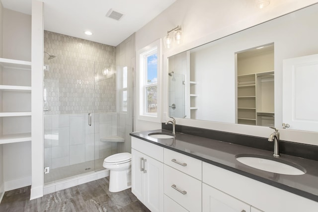 14984 Fillmore St, West Olive, MI 49460 - bathroom featuring a stall shower, double vanity, a walk in closet, and toilet