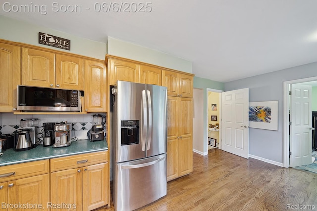 2831 Aurora Dr, Lake Orion, MI 48360 - kitchen with stainless steel appliances, decorative backsplash, light wood finished floors, dark countertops, and baseboards