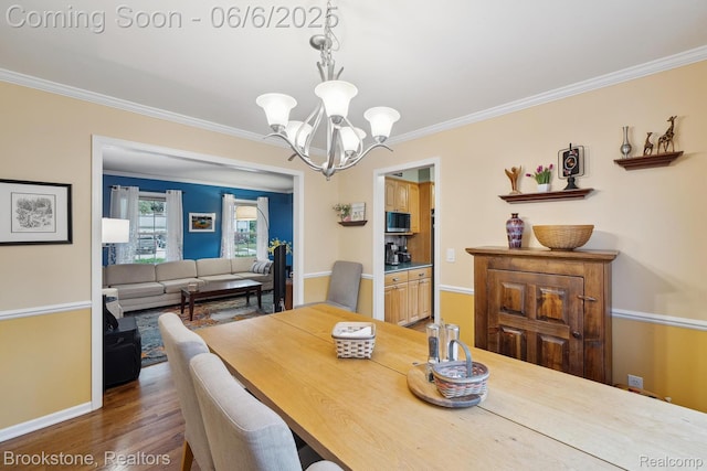 2831 Aurora Dr, Lake Orion, MI 48360 - dining space with a chandelier, crown molding, wood finished floors, and baseboards