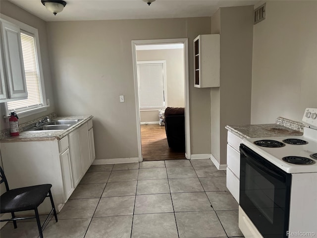 20294 Moenart St, Detroit, MI 48234 - kitchen featuring electric stove, a sink, baseboards, and white cabinetry